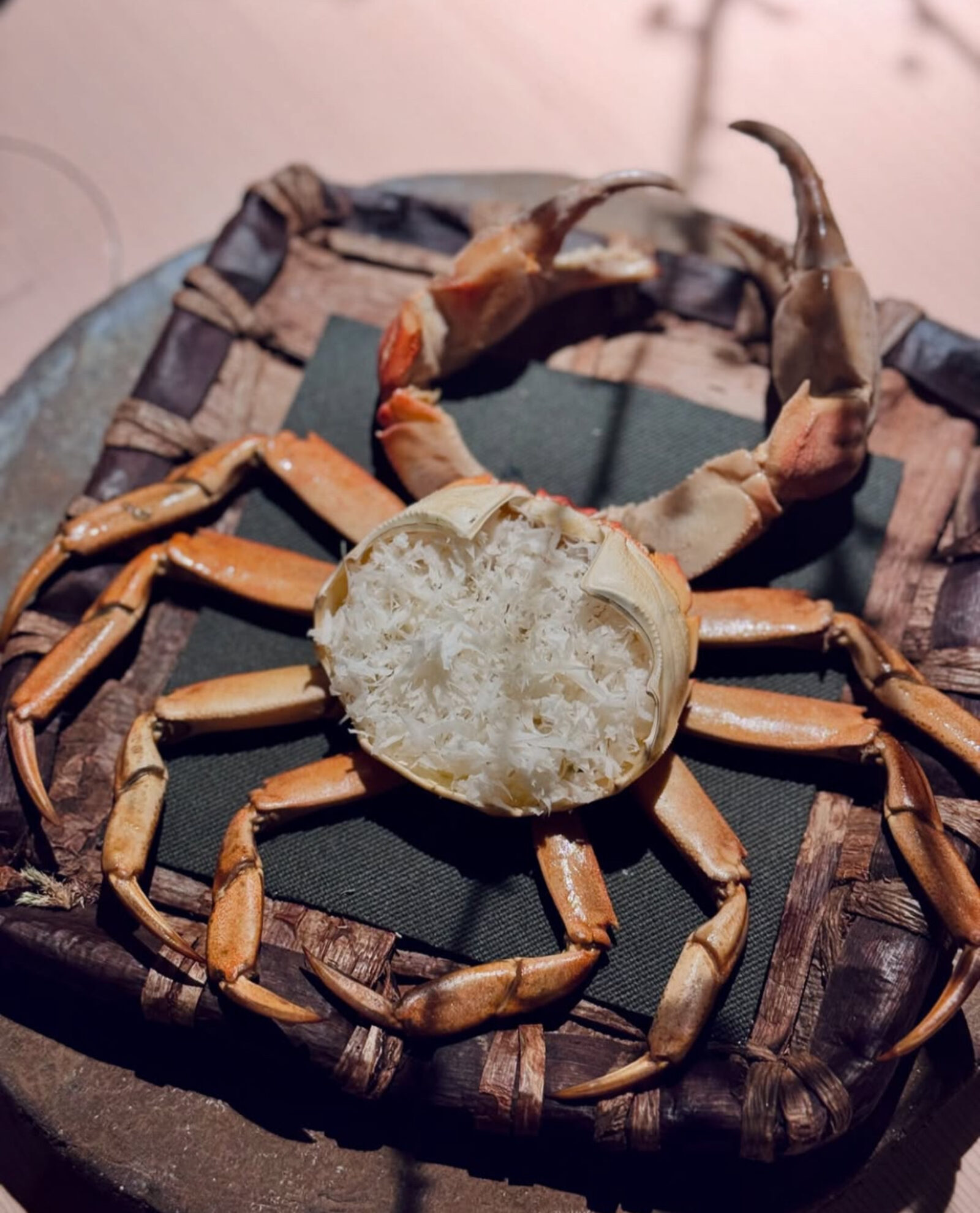 Noma dish — crab with picked crabmeat on woven mat