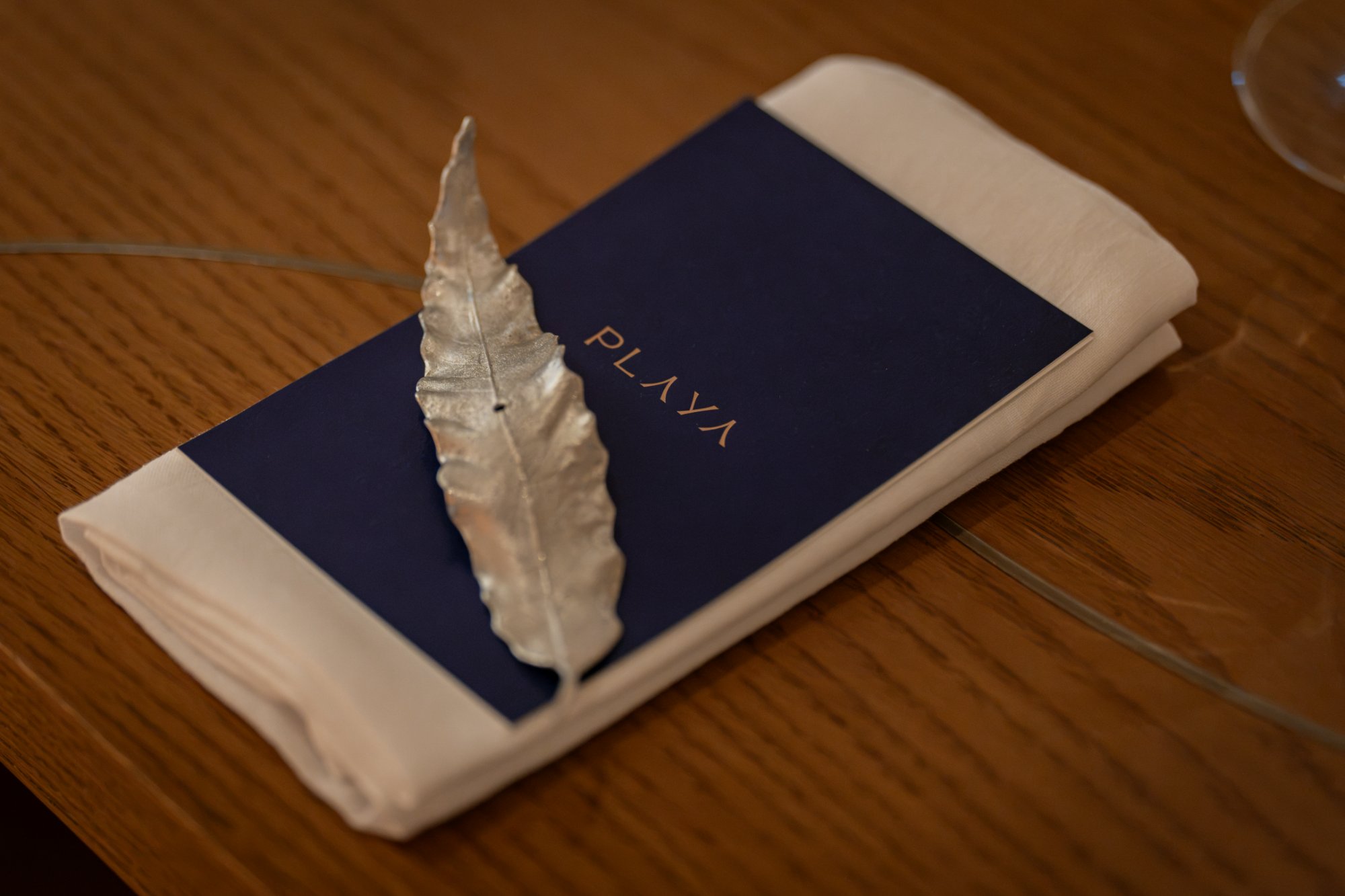 Playa × Jongin Byeon pop-up dinner table setting — PLAYA menu card & silver leaf objet