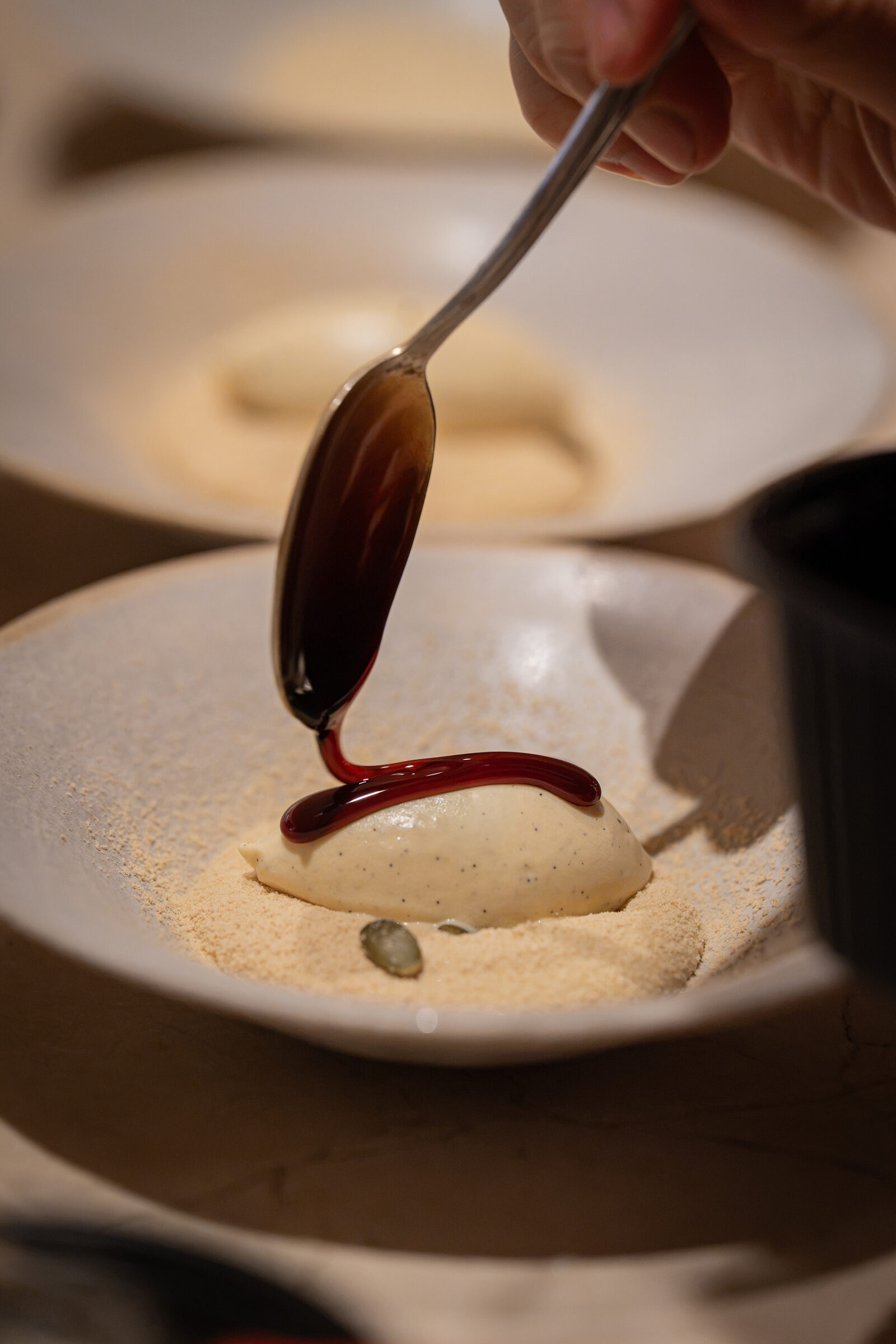Genmai matcha mousse dessert on toasted soy powder, Agrie doux sauce being poured over vanilla ice cream