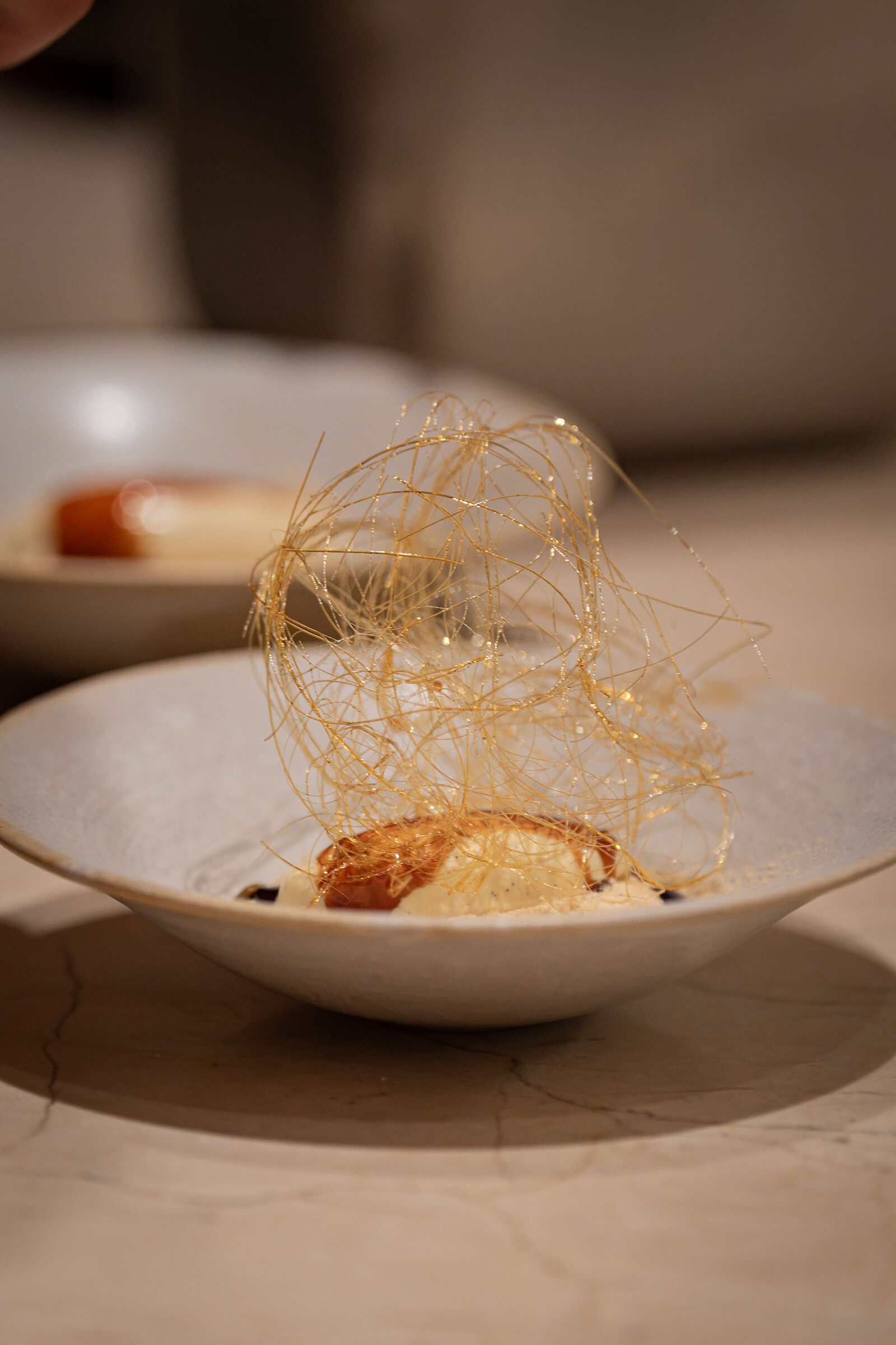 Genmai matcha mousse dessert with spun sugar nest garnish